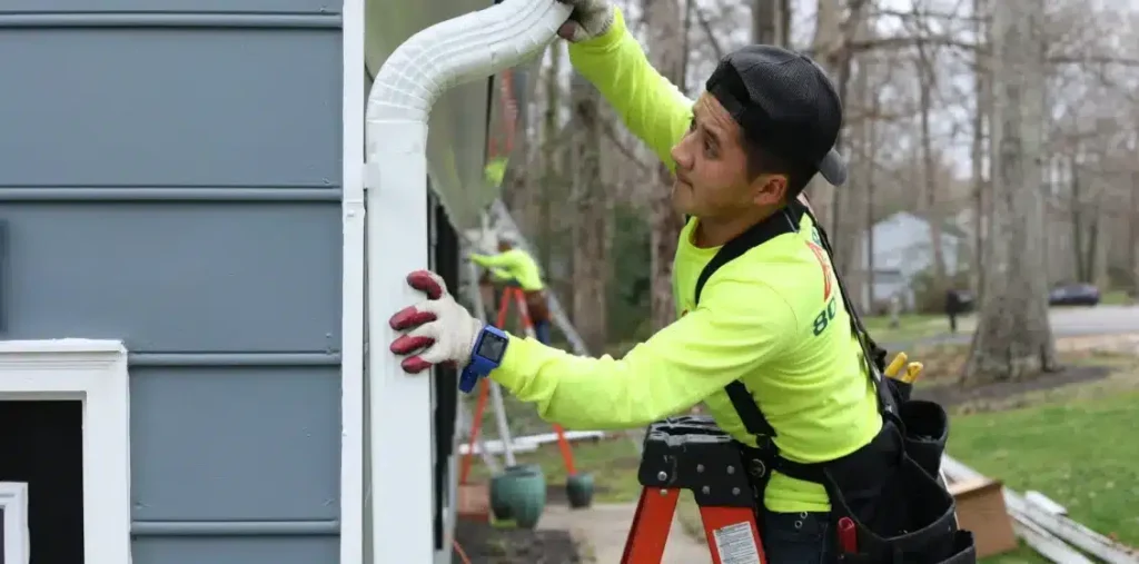A Retex technician installing a seamless gutter downspout