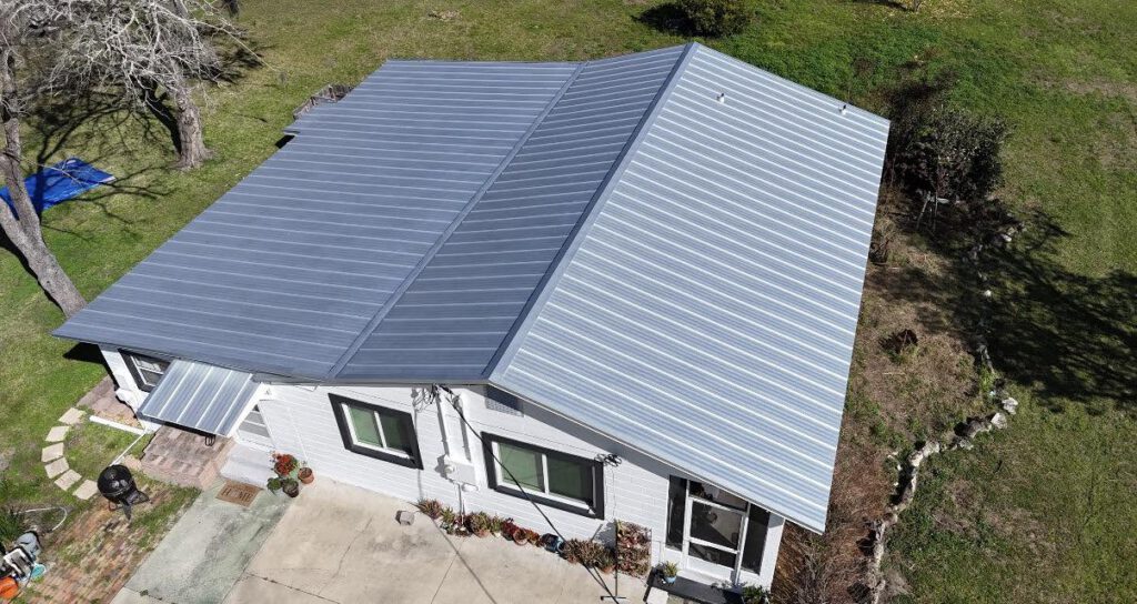 A blue-grey standing seam metal roof installed by Retex