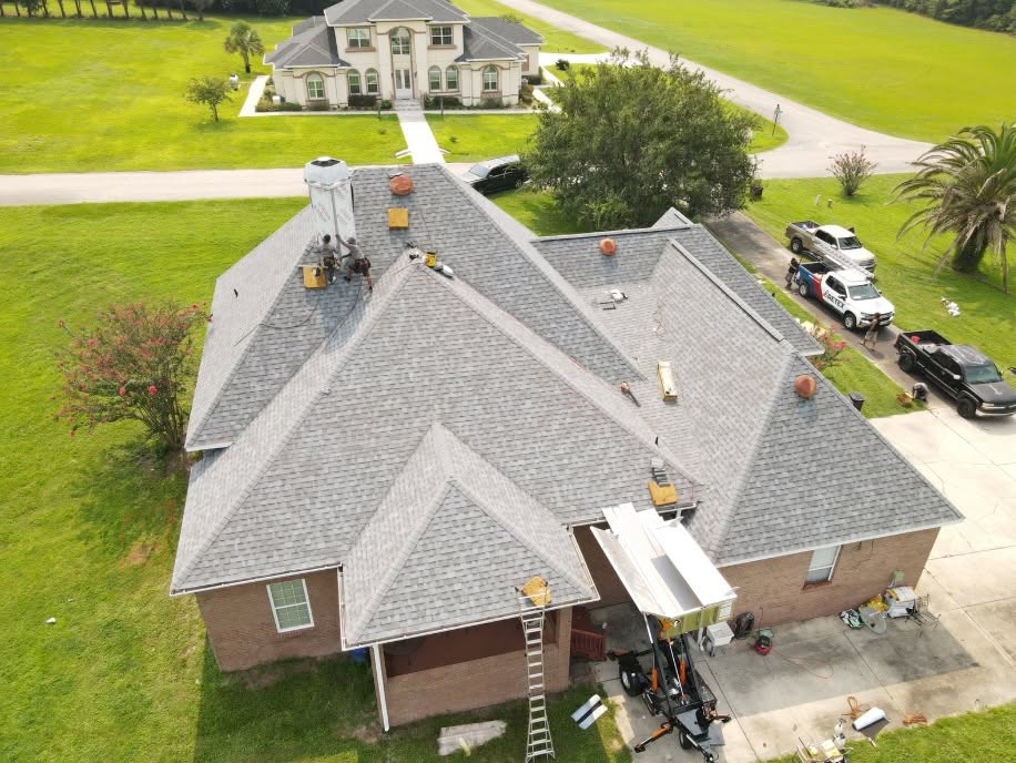 Aerial view of a Retex crew staged on a roof with ladders and materials in place
