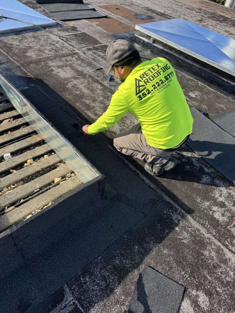 A Retex technician in a branded shirt sealing the flashing at a skylight kerb